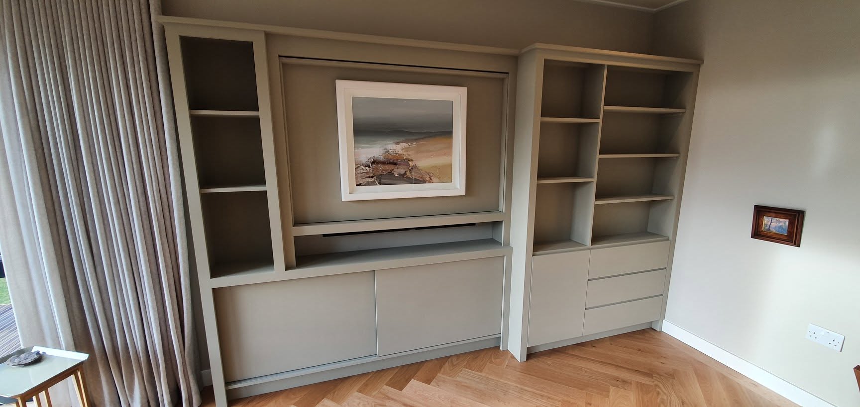 Painted fitted cabinets and shelving with a framed picture